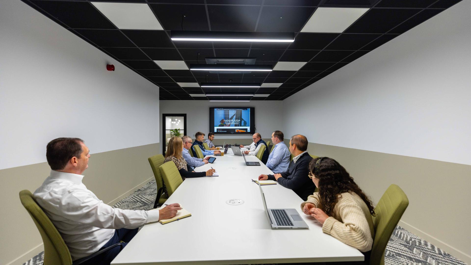Obex employees gathered in a conference room designed by Rhino Interiors.